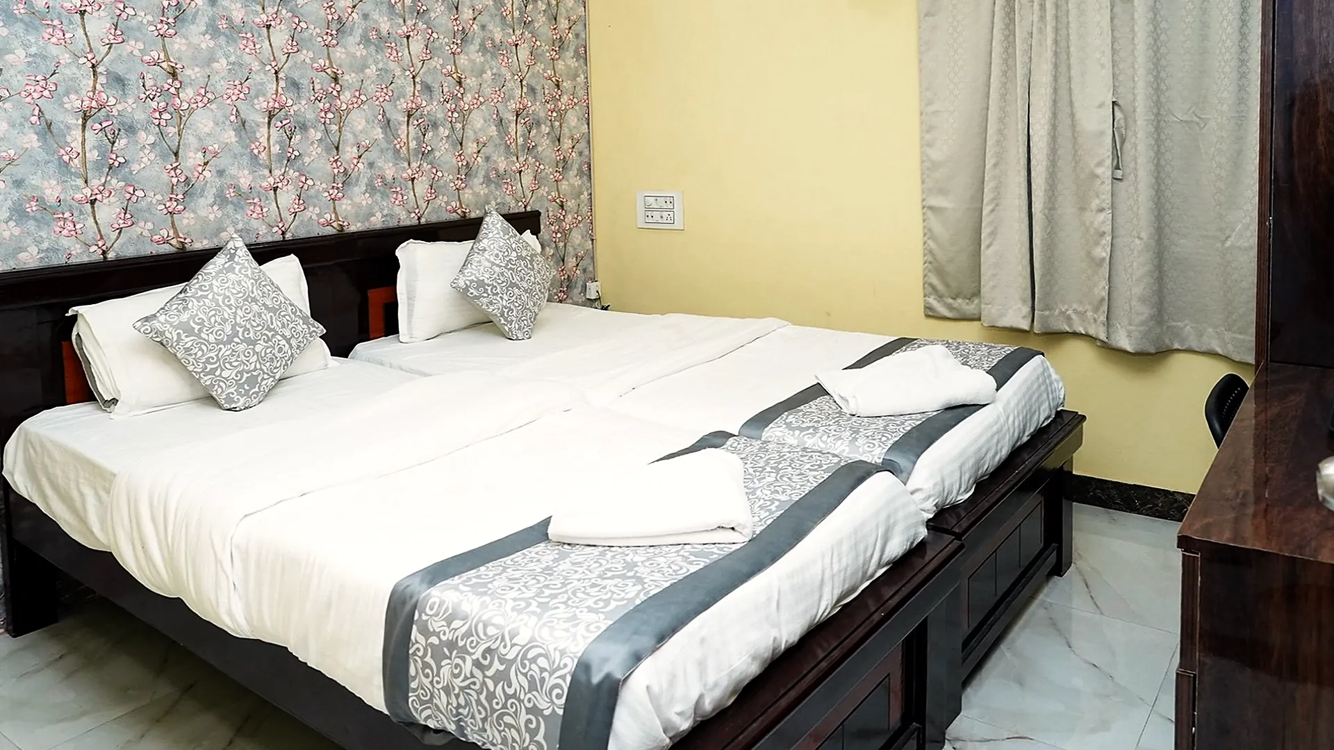 A guest room with white bedding at Hotel Hyderabad Pulse